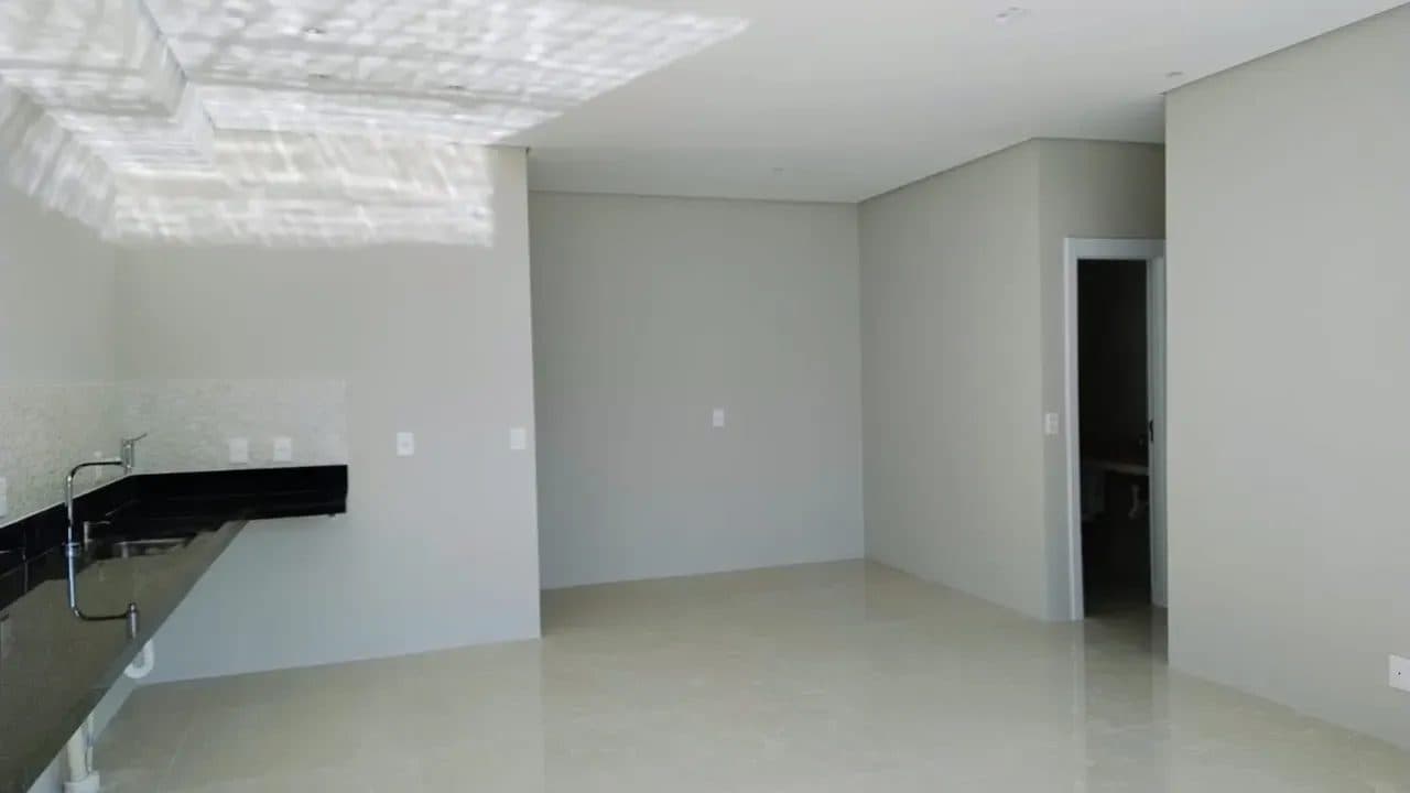Ambiente de sala integrado com piso em porcelanato claro e paredes em tom neutro.
