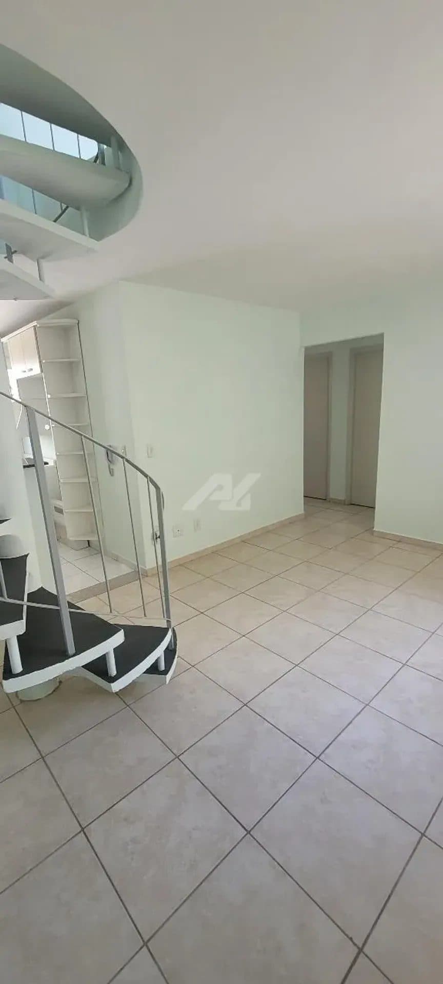 Sala com piso frio e escada caracol em metal.